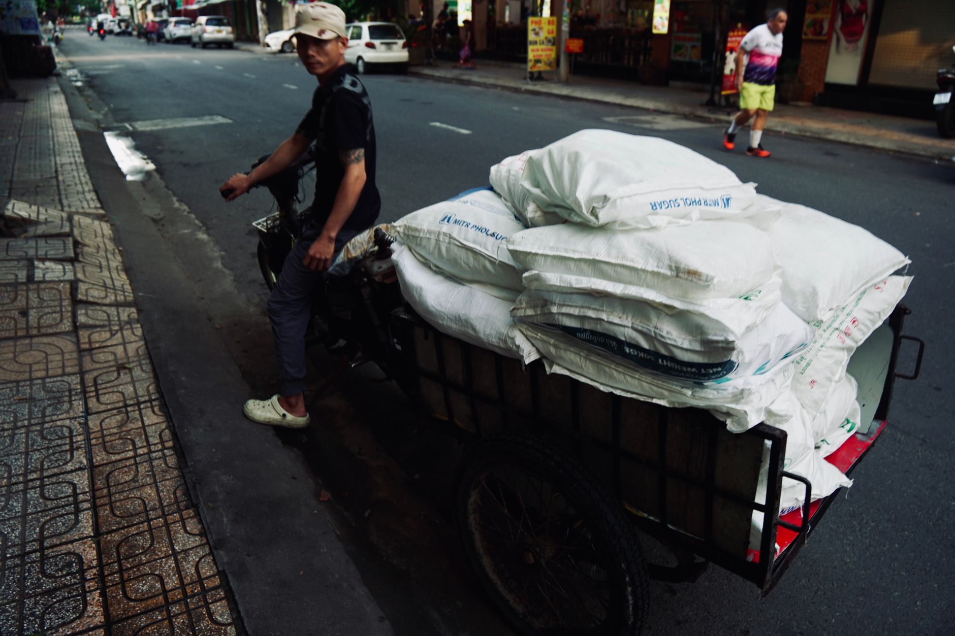 On the broad upstairs landing of a UK terraced home, a professional two-person delivery crew carefully carrying a large…