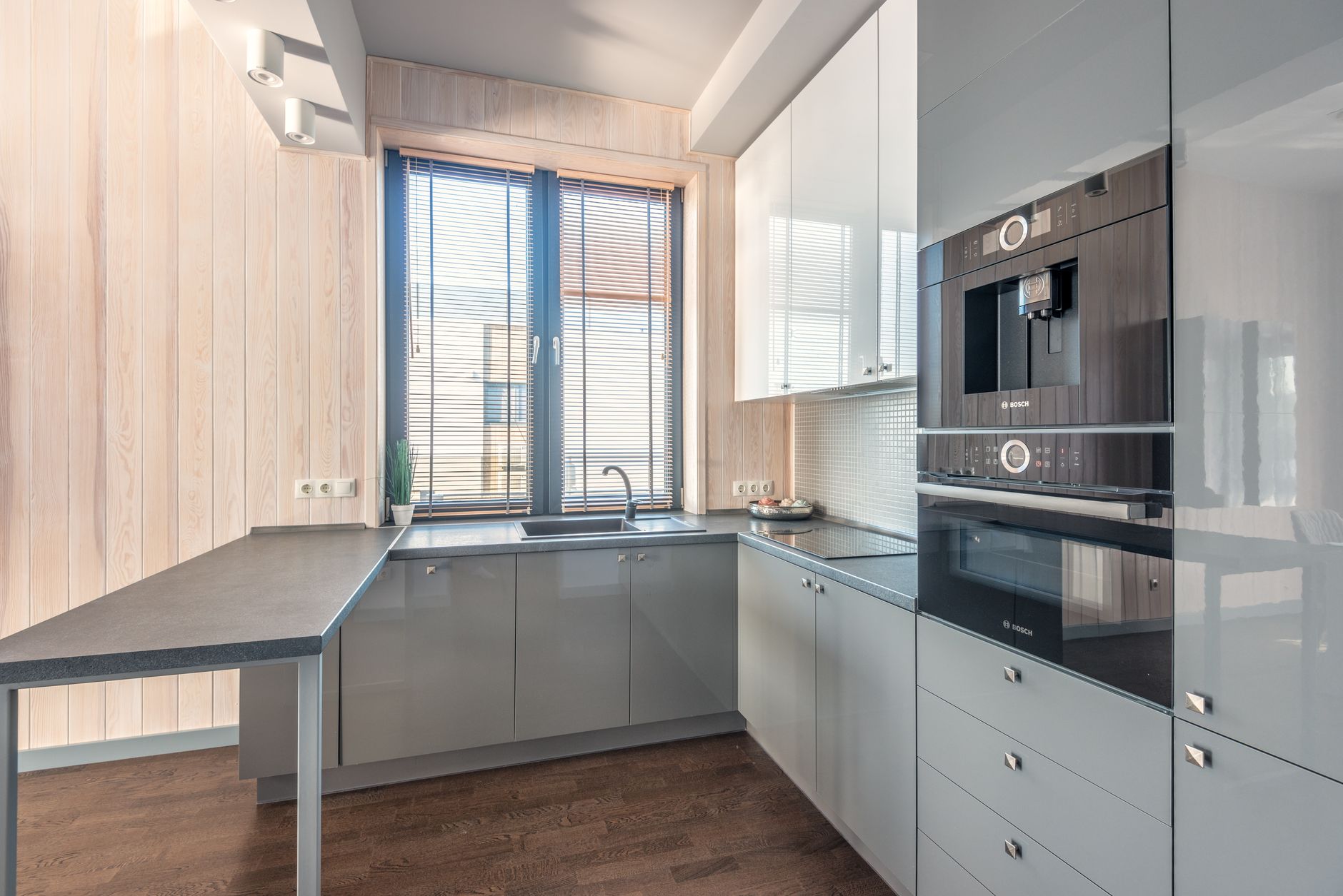 In a lived-in UK kitchen, a professional two-person installation crew completing the handover of a newly fitted built-in…