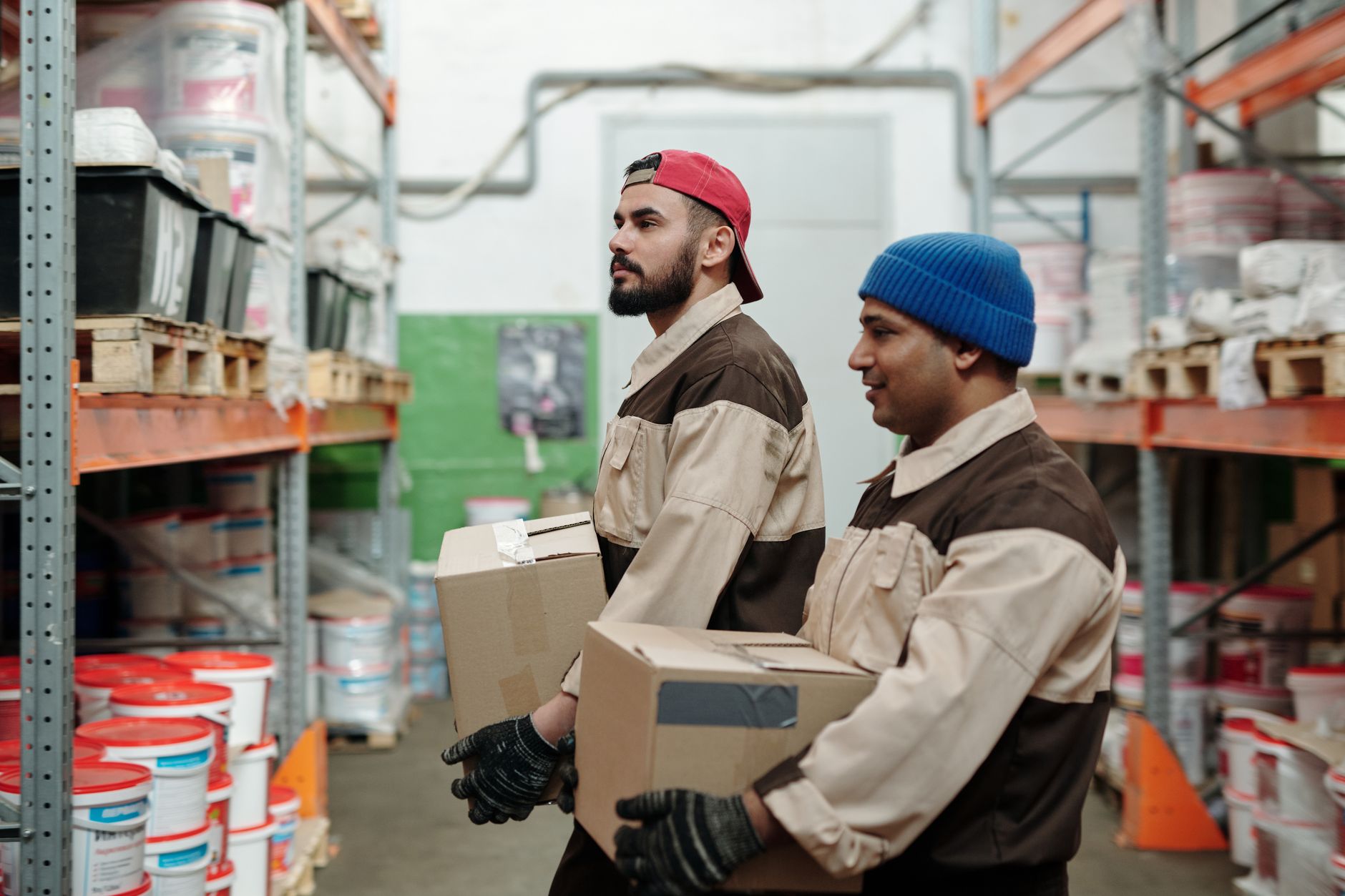 Inside a UK delivery outbase: two ordinary delivery crew members checking appliance securing straps inside a stationary…