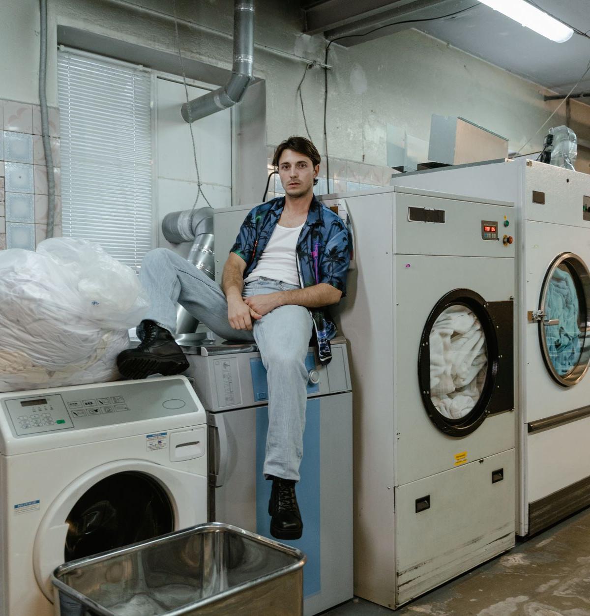 Two delivery crew members carefully setting a washing machine in a customer's kitchen