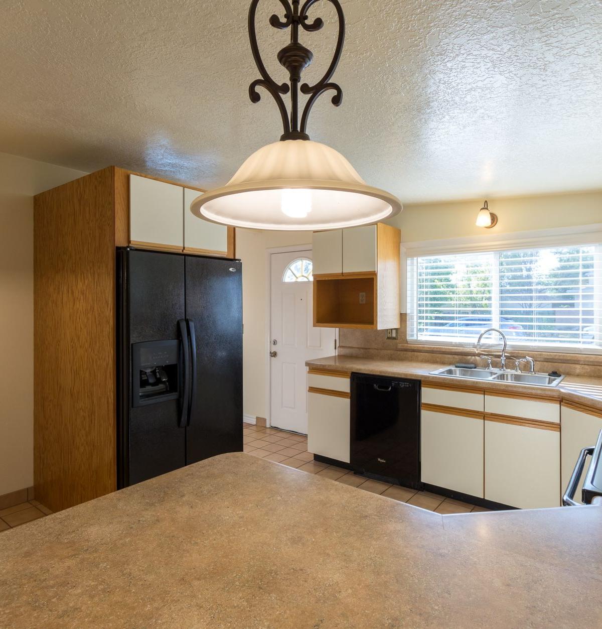 Delivery crew professionally installing a refrigerator in a customer's kitchen