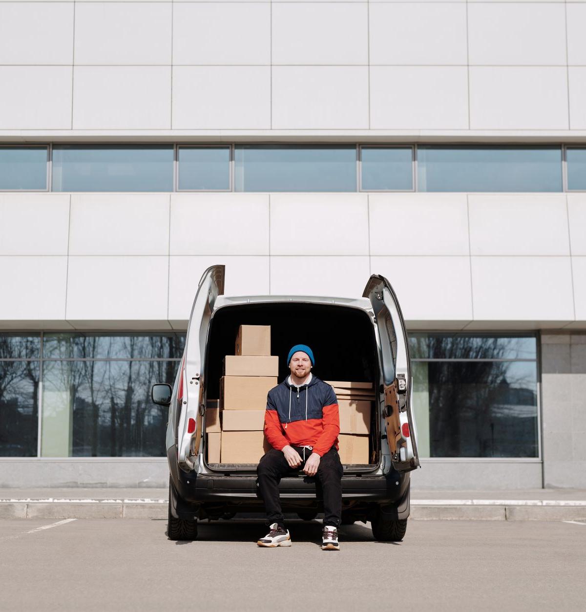 Delivery van parked in a leafy UK street as drivers prepare to unload furniture