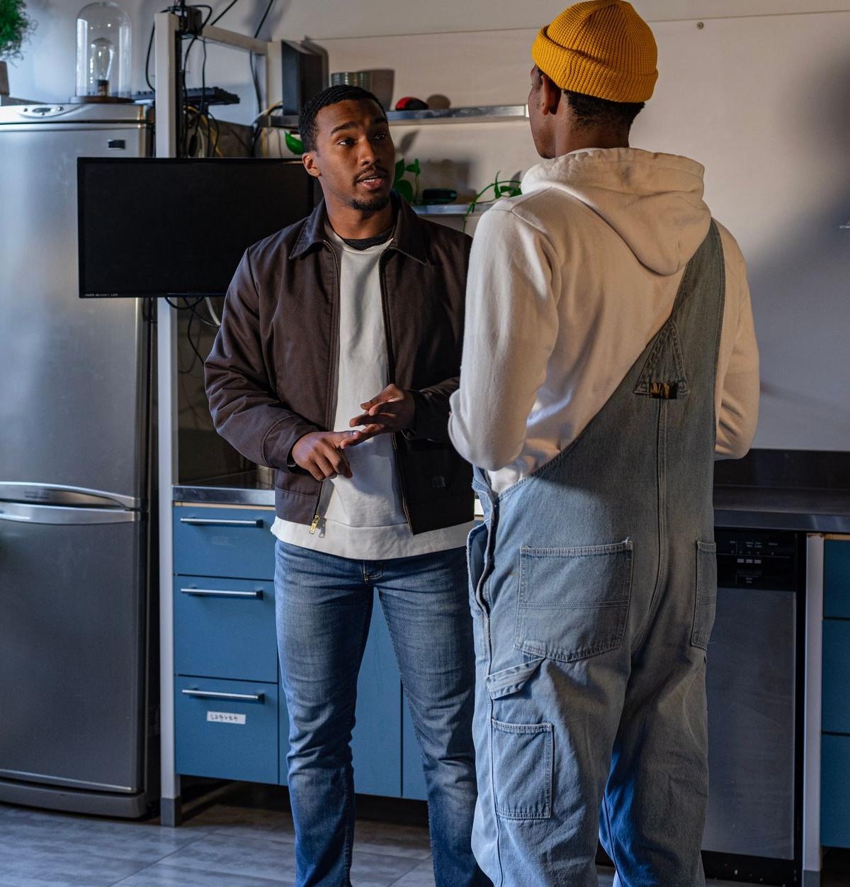 Two self-employed delivery personnel installing a refrigerator