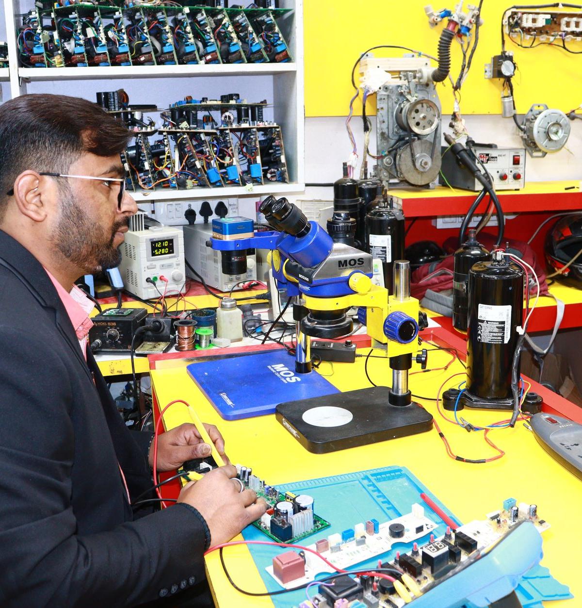 In a UK appliance training space, practical workwear, natural working interaction