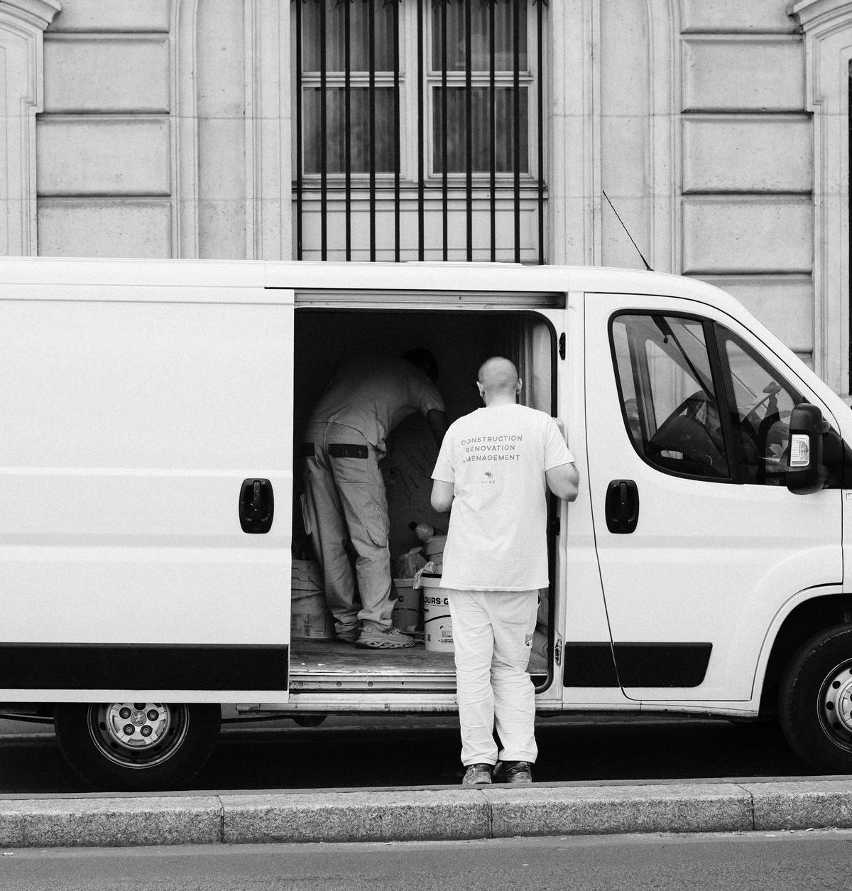 Self-employed delivery team unloading a sofa from a van in a London street