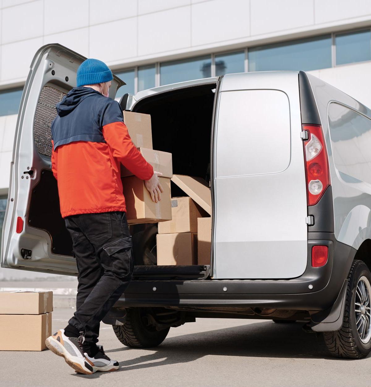 Self-employed delivery crew unloading new washing machines in a residential UK neighbourhood