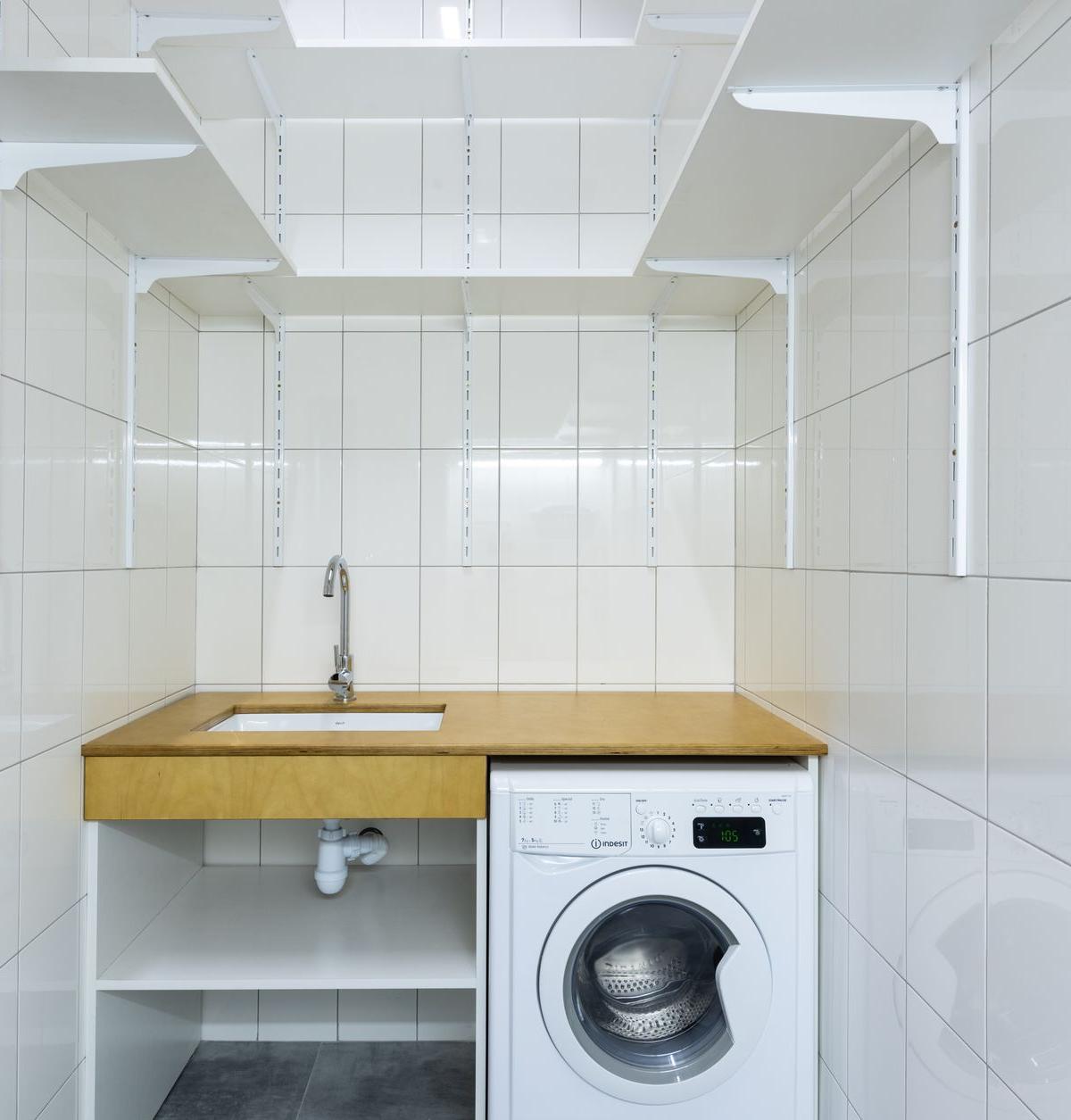 Delivery team installing a new washing machine in a spacious UK kitchen